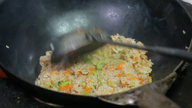 Vegetable fried rice being stirred in a pan