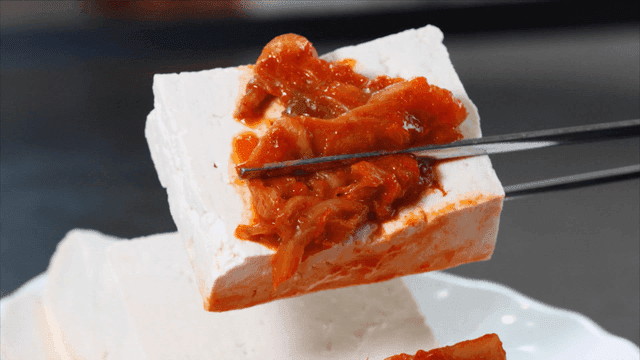 Tofu topped with kimchi on a plate