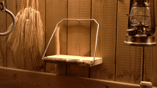 손이 수제 나무 선반에 휴대폰을 놓는 장면