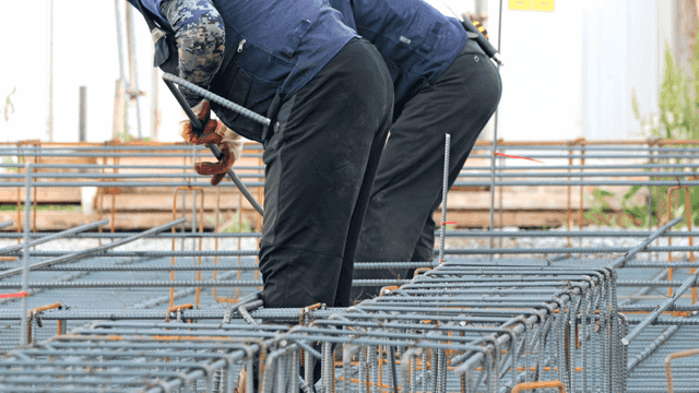 Construction workers handling rebar