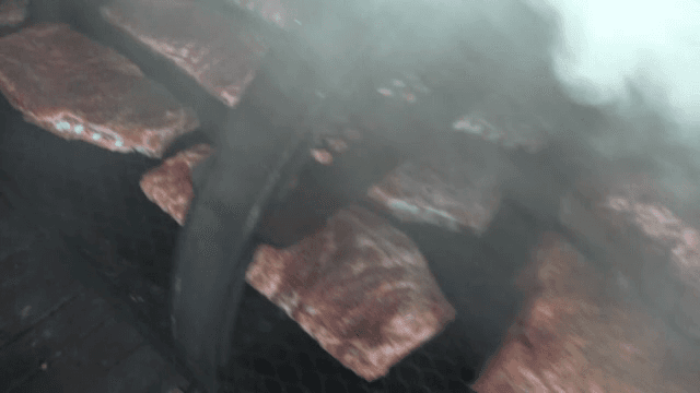 Ribs cooking on a smoky grill