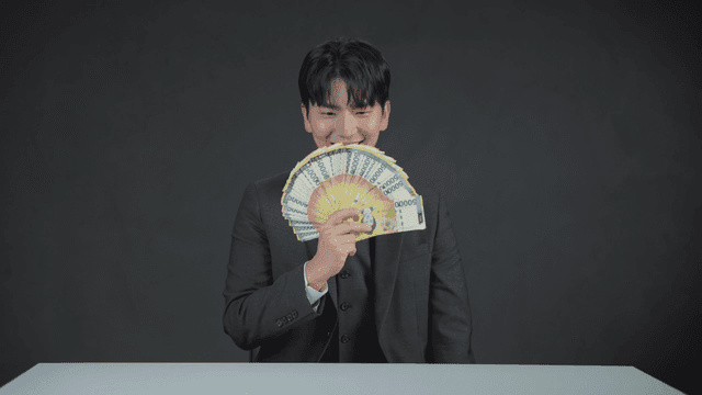 정장을 입은 남자가 돈을 들고 기뻐하는 모습