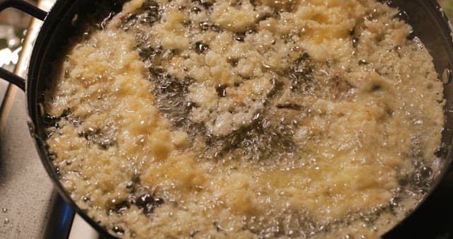 뜨거운 팬에 음식을 튀기는 모습