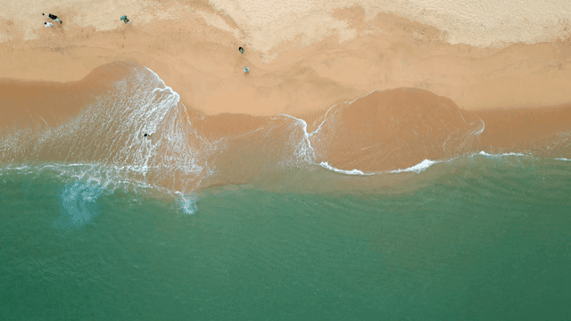 Aerial view of a sandy beach with waves