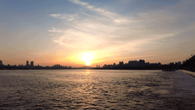 Sunset over a river with city skyline