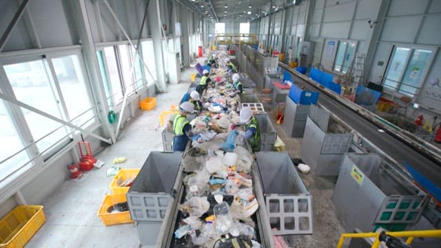 Workers at a recycling center sorting plastic waste