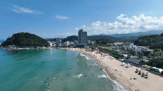 A bustling beach with people enjoying the sea