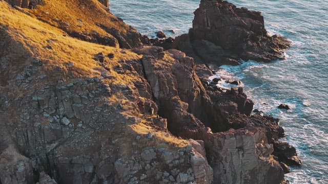 Rocky Coastline with Waves at Sunset 