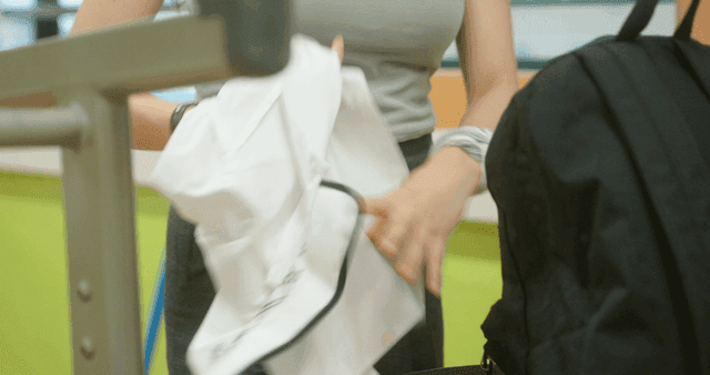 Student taking off a school uniform