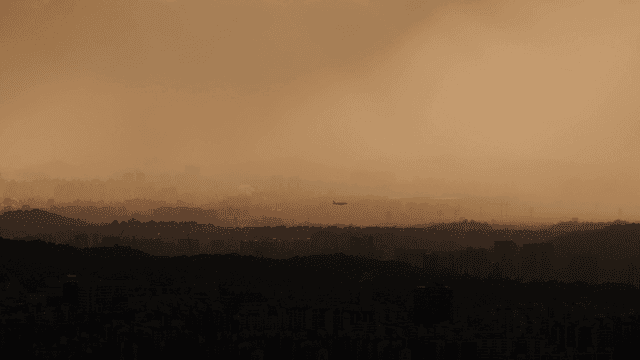 일몰 도시에 착륙하는 비행기