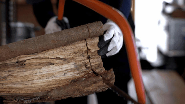 거친 통나무를 톱질하는 목수