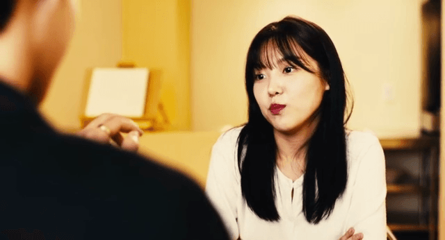 Woman talking to man while looking at ring indoors