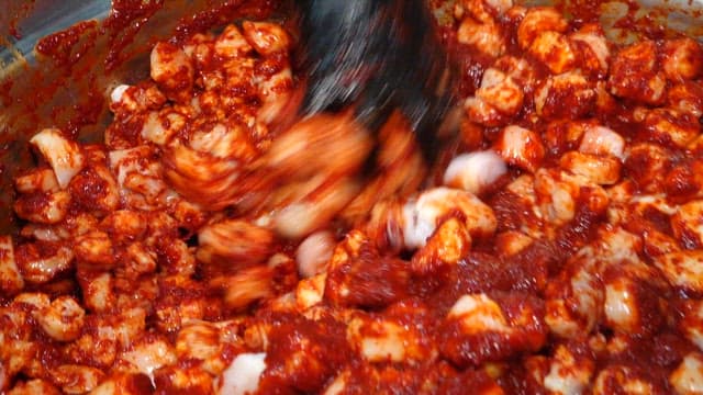 금속 대야에서 빨간 양념과 버무려지는 곱창