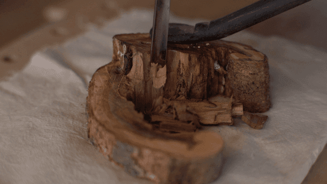 탁자 위에서 끌로 나무 조각 작업