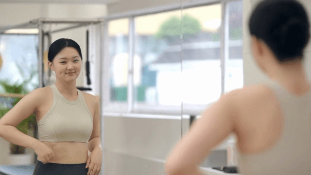 거울 앞에서 근육을 자랑하는 여성