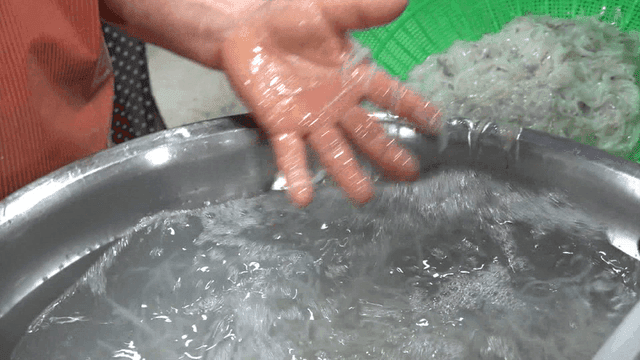 큰 금속 대야에서 씻겨지는 실치 더미