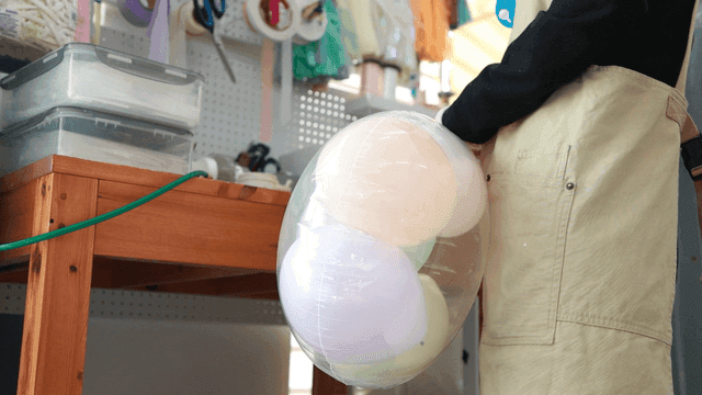 Person holding balloons in a workshop
