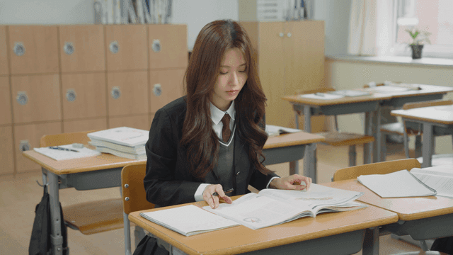 교실에서 교과서를 보며 공책에 필기하는 학생