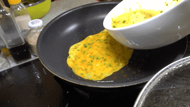 Pouring vegetable and egg mixture into pan