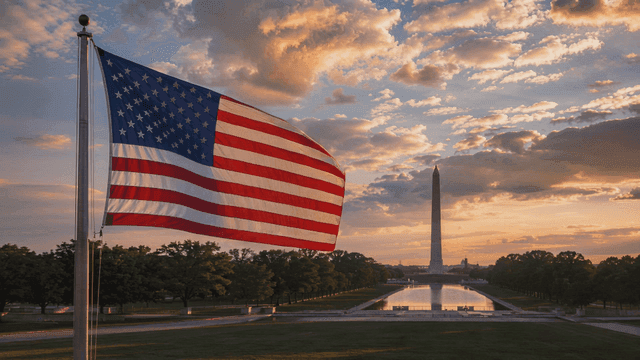 American flag at sunset with monument