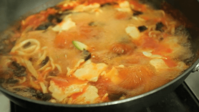 빨간 국물에 반죽을 뜯어 넣는 손