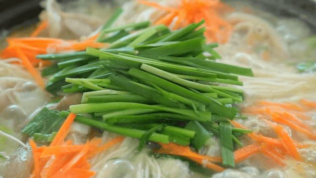 Pot of boiling braised pig's feet soup with vegetables