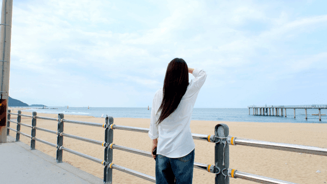Back view of woman looking at sea on beach