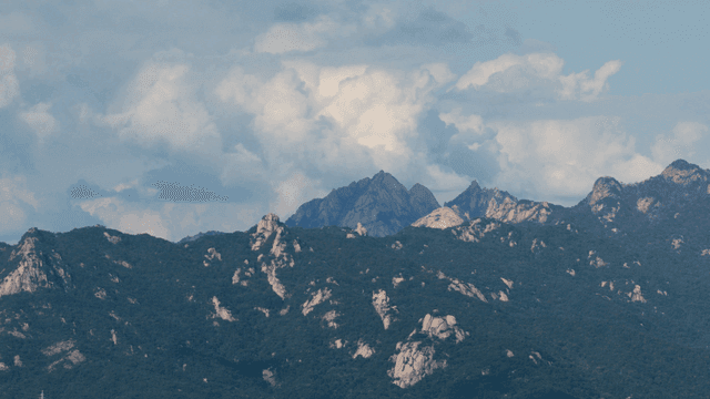 구름 낀 하늘 아래 산맥
