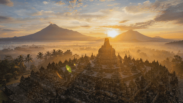 Sunrise over foggy mountains and Southeast Asian temple