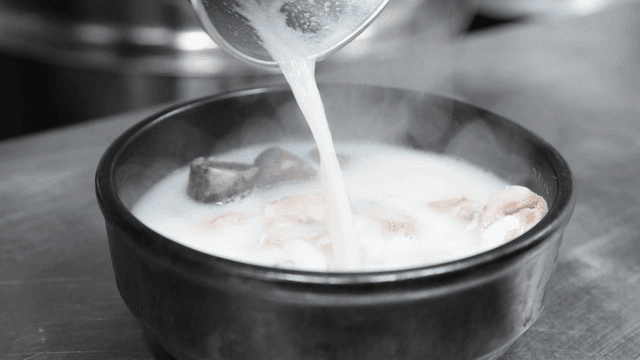 Broth poured over sundae soup containing sundae and pork