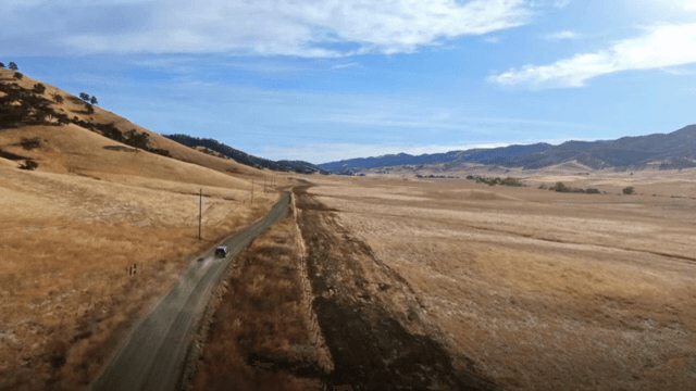 Car driving through a vast open landscape