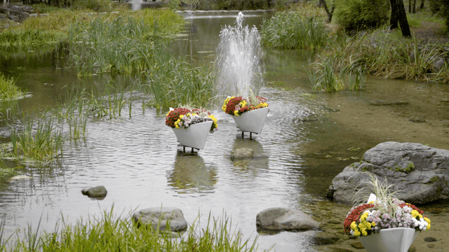 Flower vessels with fountain on quiet pond