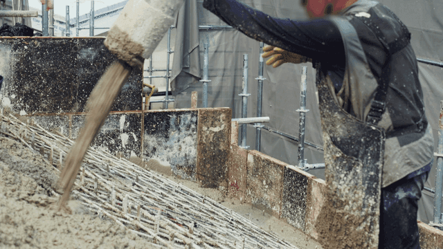 건설 현장에서 콘크리트를 붓는 작업자