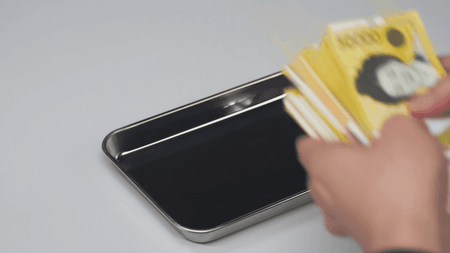트레이에서 한국 원화를 집어드는 손