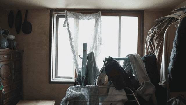 Cluttered room with clothes and window