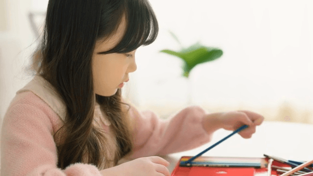 Young girl drawing with colored pencils