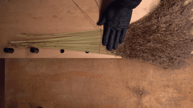 테이블 위에서 마른 갈대로 공예하는 손