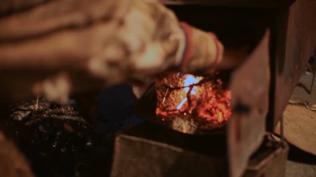 Making a Fire by Putting Dry Branches in a Traditional Brazier
