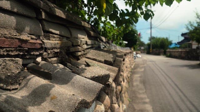 Old stone wall by the road in a quiet village