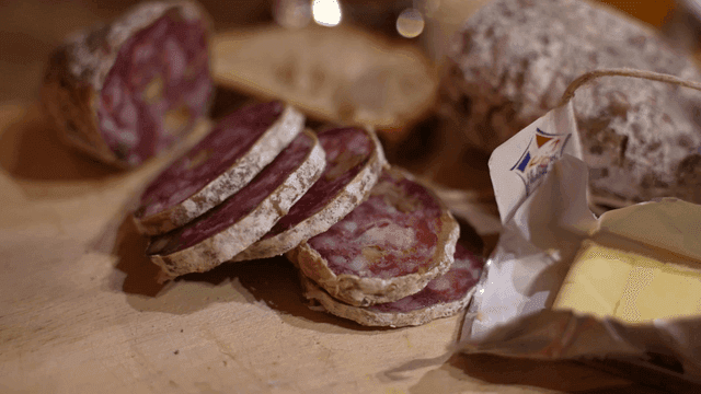 Sliced salami and butter on a wooden board