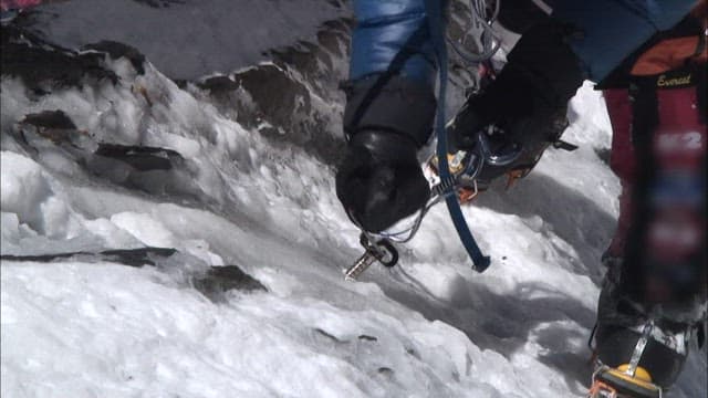 Climber Ascending a Snowy Mountain Slope