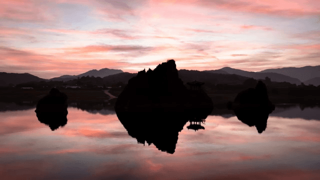 Silhouette of rocks and pavilion at sunset