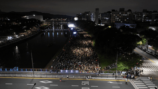 Night city festival and crowds along river