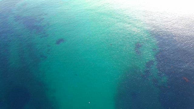 물 속 지형이 비치는 에메랄드빛 바다