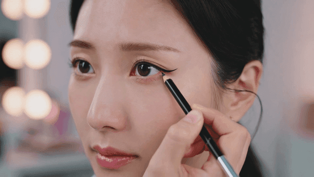 Applying eyeliner on a woman's eye