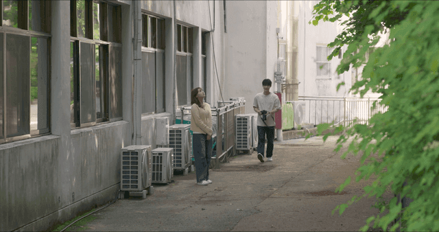 Man with camera approaching woman