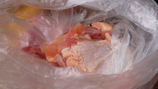 Seasoning chicken with salt and pepper in a plastic bag