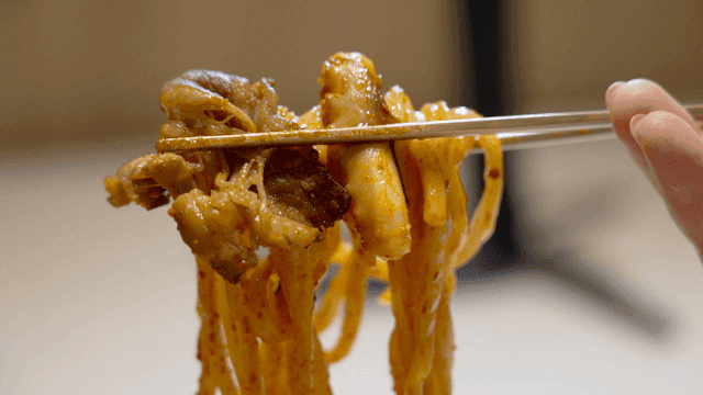 Chopsticks holding spicy noodles