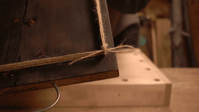 여러 겹의 줄이 묶인 못이 박힌 나무 판자