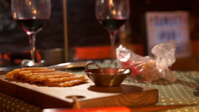 Cozy dinner with red wine and cold cuts on a wooden cutting board